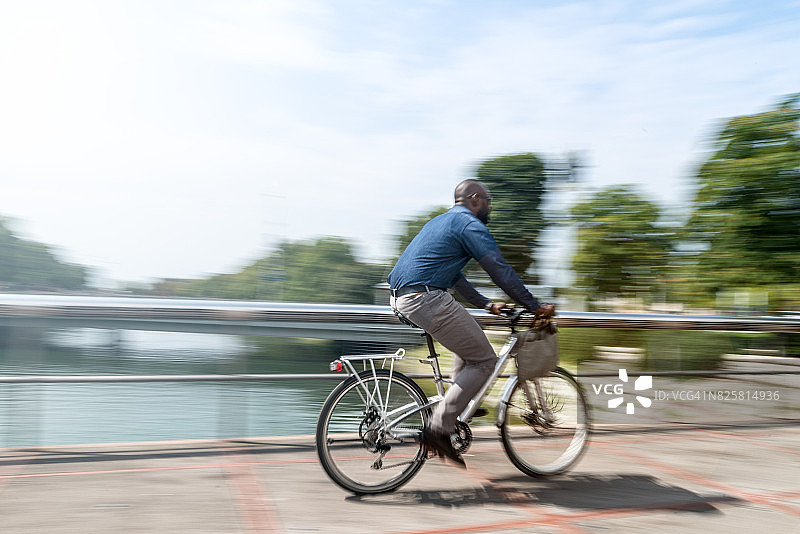 骑着城市自行车的商人穿梭于城市中图片素材