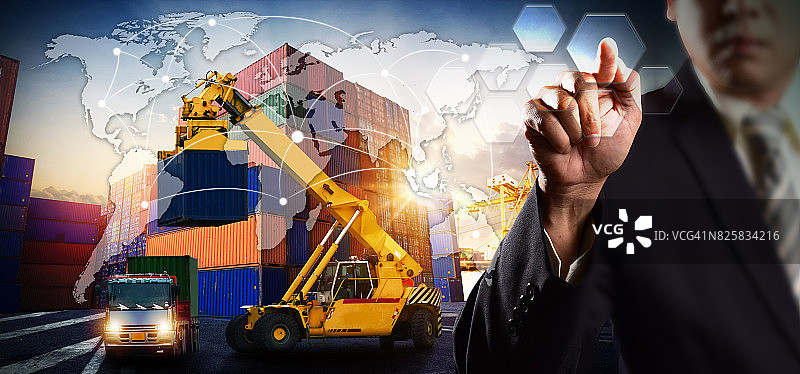 叉车装卸集装箱，货轮在船坞起重机桥下作业图片素材