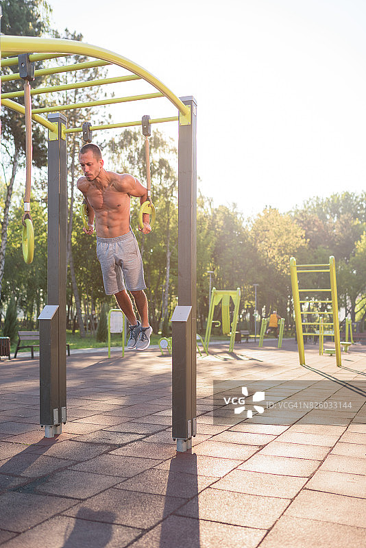 健壮的白人男子抓住吊环增强肌肉图片素材