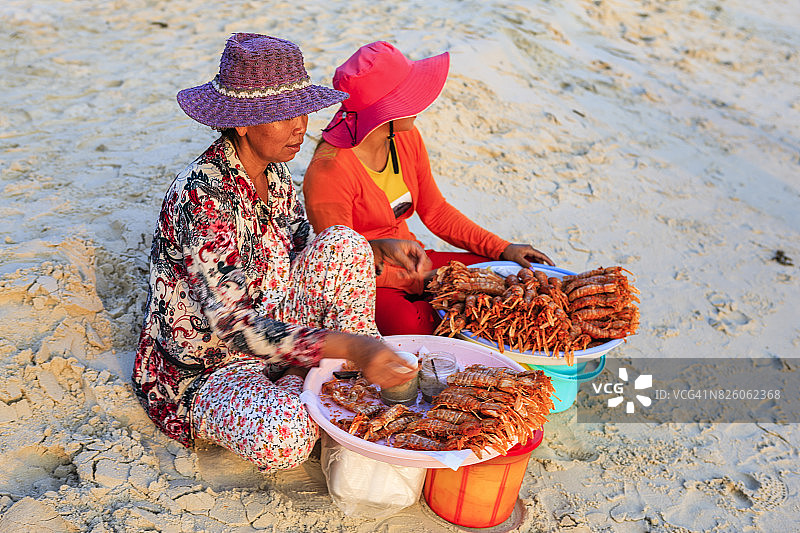 柬埔寨西哈努克市海滩上出售新鲜龙虾的柬埔寨妇女图片素材