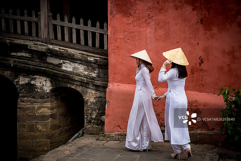 穿着越南奥黛的中国台湾女学生在日本廊桥，越南会安图片素材
