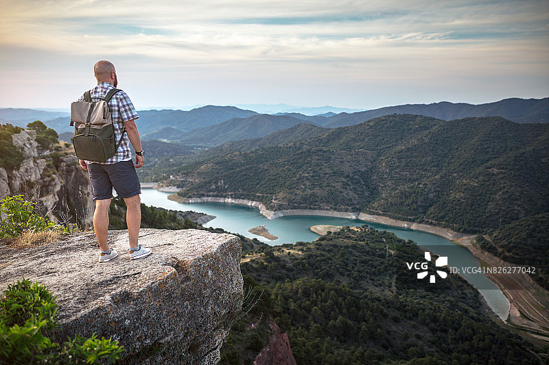 旅行者站在岩石边缘，眺望山谷图片素材