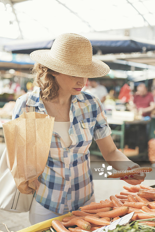 中年妇女在农贸市场购买胡萝卜图片素材