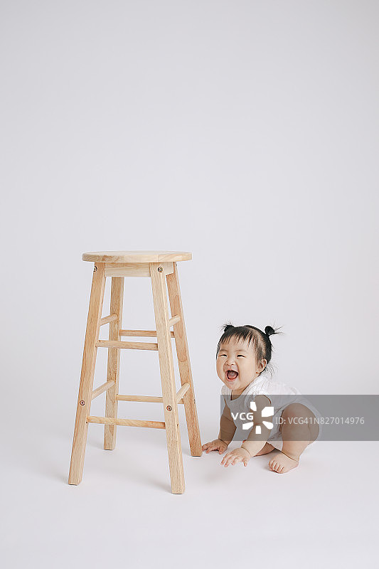 女婴玩木制高脚椅图片素材