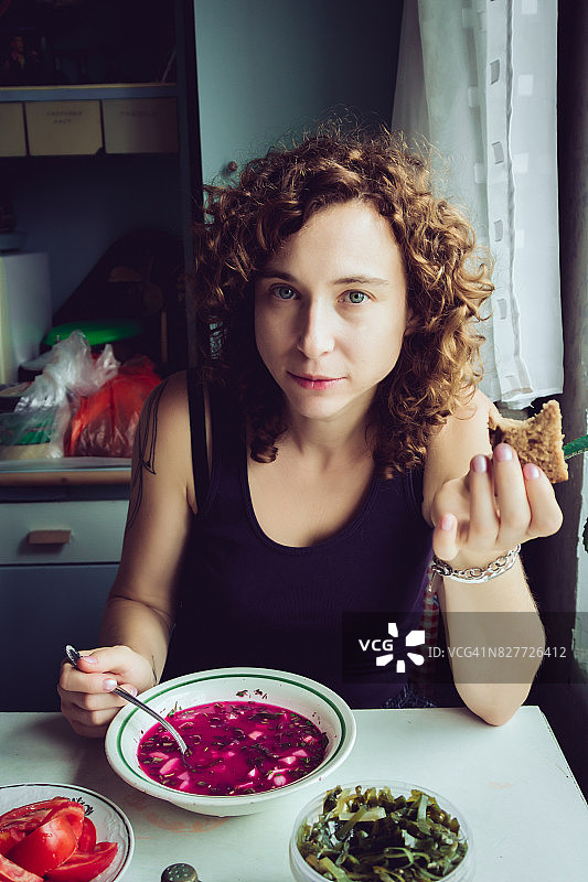 在母亲厨房吃乌克兰红菜汤的女人图片素材
