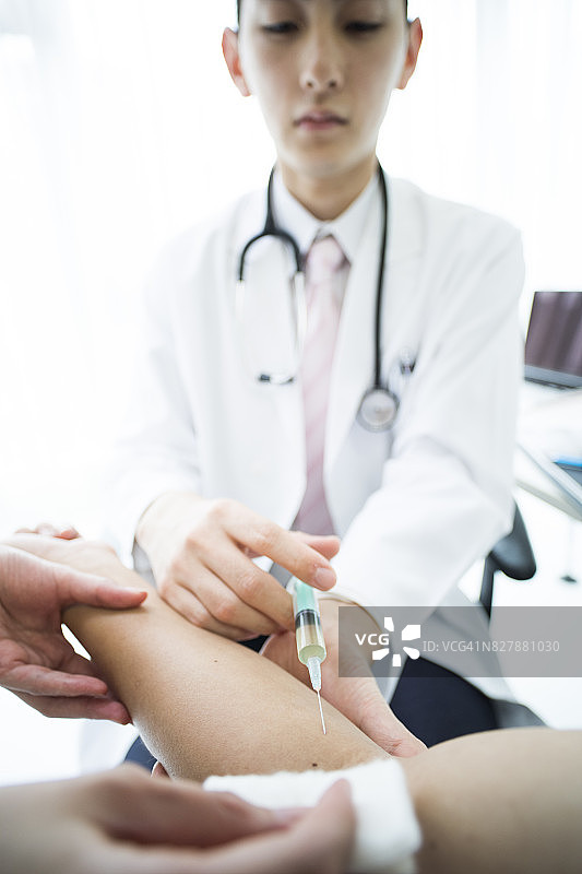 医生表情严肃地试图给病人注射图片素材