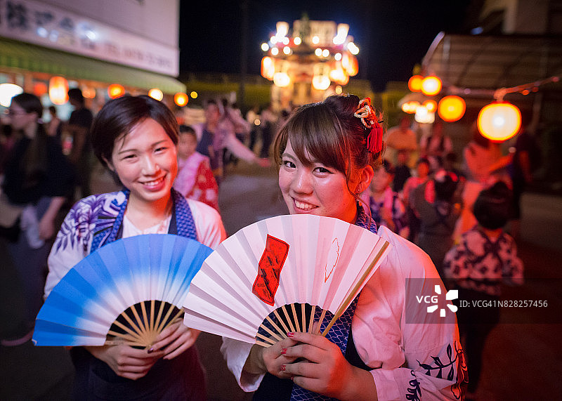 年轻的祭典舞者在彩车前合影图片素材