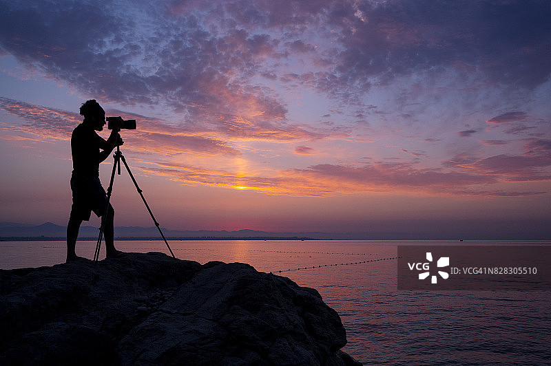 摄影师在黎明时分拍摄日出图片素材