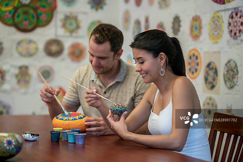 幸福情侣在石头上绘制曼陀罗图片素材