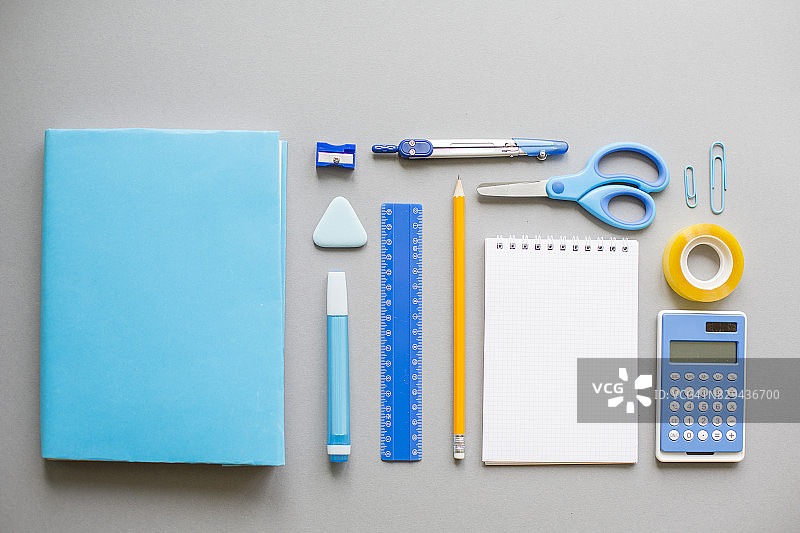 灰色背景上的蓝色学校用品图片素材