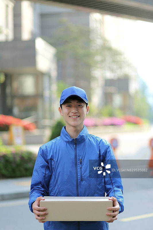 快递员 holding 包裹图片素材
