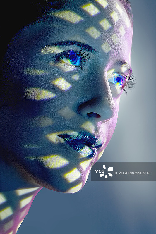 蓝色口红女性面部特写，三角形和菱形灯光投影图片素材