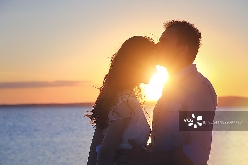 新郎在户外亲吻新娘的额头图片素材