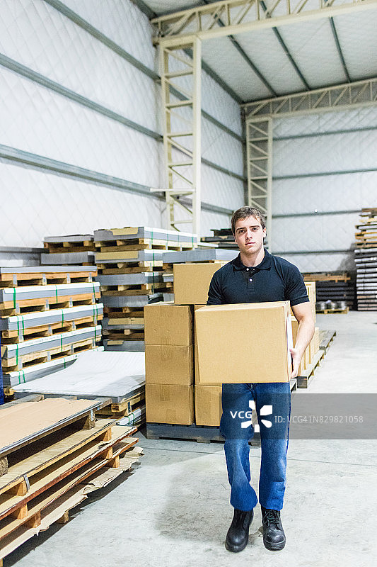 工人在工厂仓库搬运纸箱图片素材