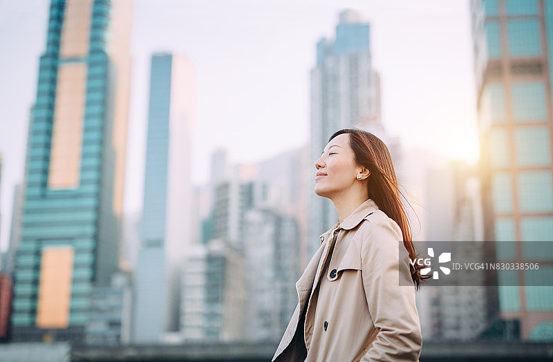 在城市屋顶露台上深呼吸的美丽女人图片素材