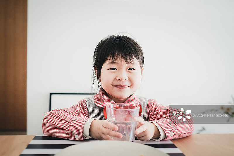 可爱的亚洲女孩喝完牛奶，吃完午餐，感到快乐和满足图片素材