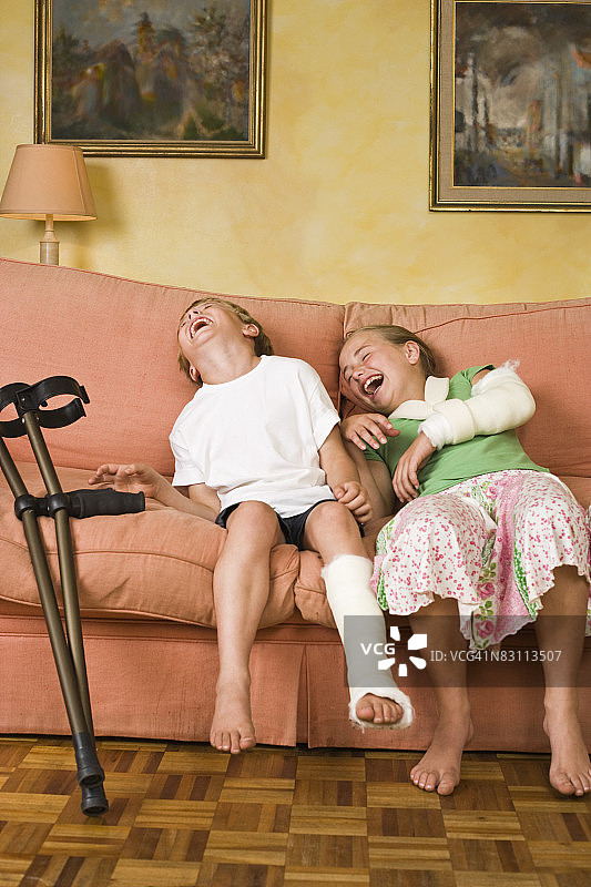 受伤儿童在沙发上欢笑图片素材