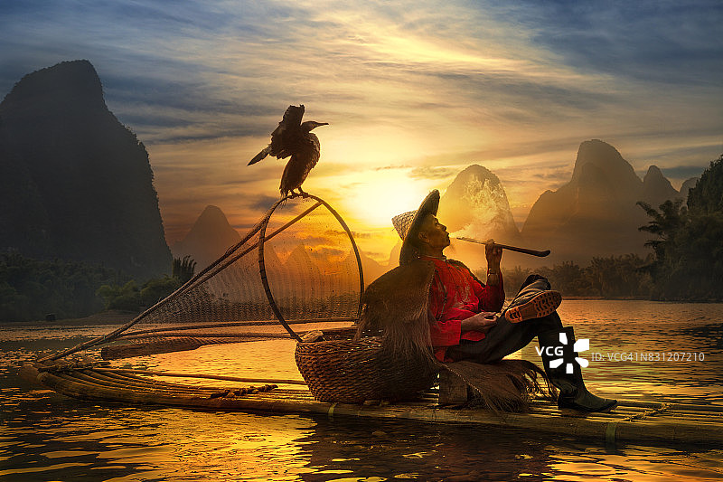 阳朔日落时分抽烟斗的鸬鹚渔夫图片素材