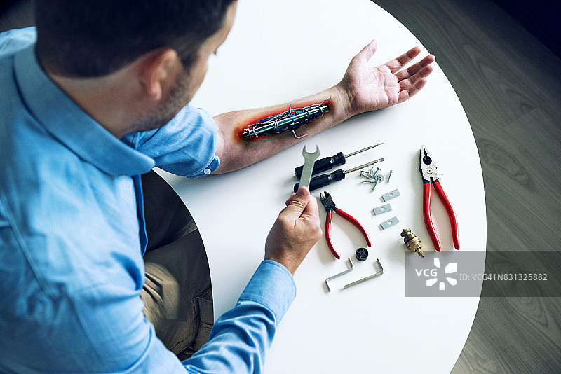 创新助力：男子手臂与机器人部件图片素材