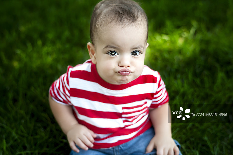 12个月大的宝宝坐在甲板上欢笑图片素材