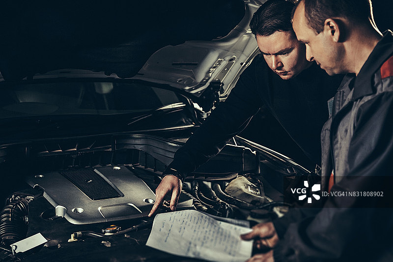 在汽车修理店修理汽车的专业汽车机械师图片素材