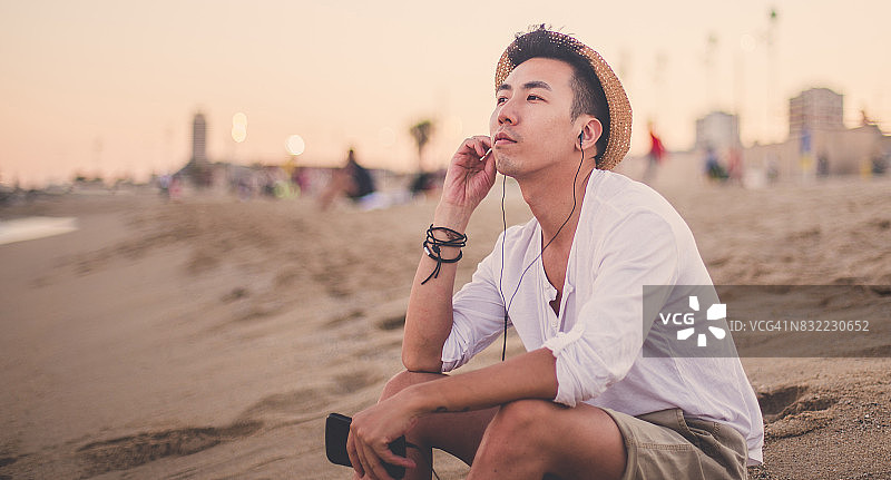 坐在海滩上的英俊男人图片素材