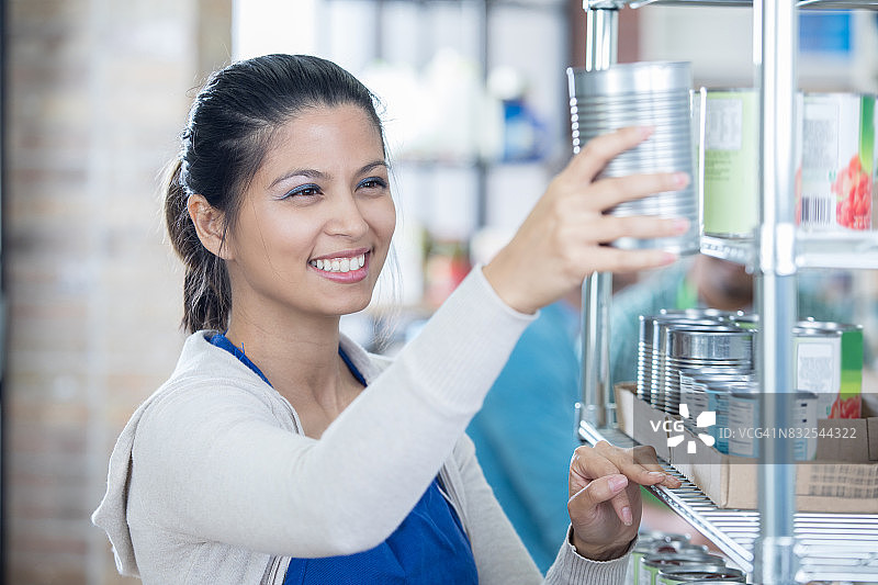 快乐的女志愿者整理食物银行储藏室图片素材