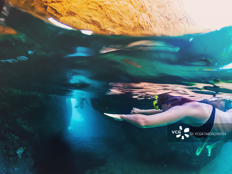 女孩在布拉瓦海岸洞穴浮潜，用相机记录水下风光图片素材