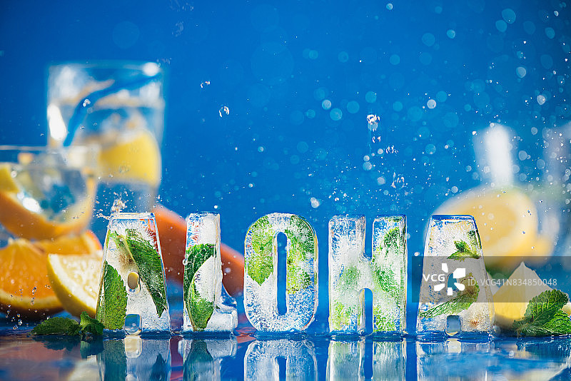 冰块字母与薄荷叶柠檬片橙子蓝色背景水花图片素材