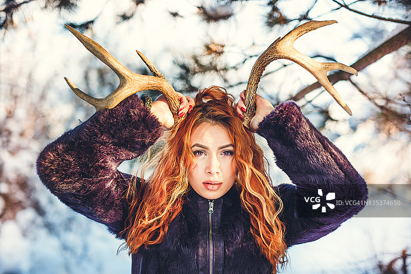 冬天戴着鹿角的红发女孩图片素材