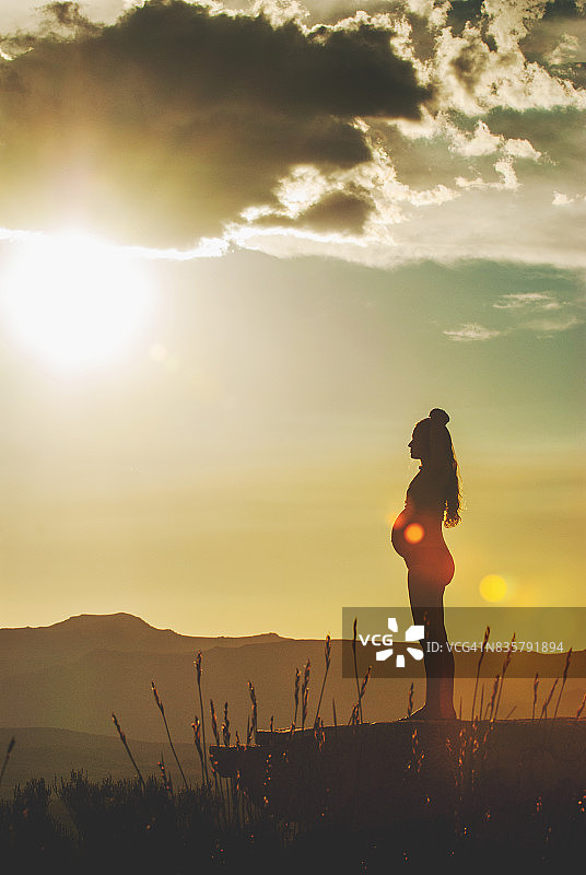 户外日落时放松的孕妇图片素材