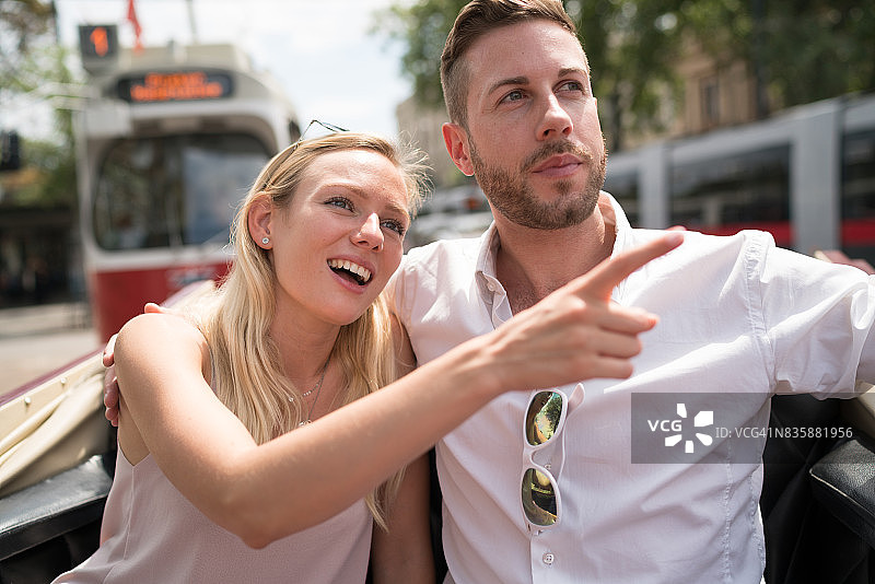 城市休闲：年轻夫妇在维也纳乘坐马车观光图片素材