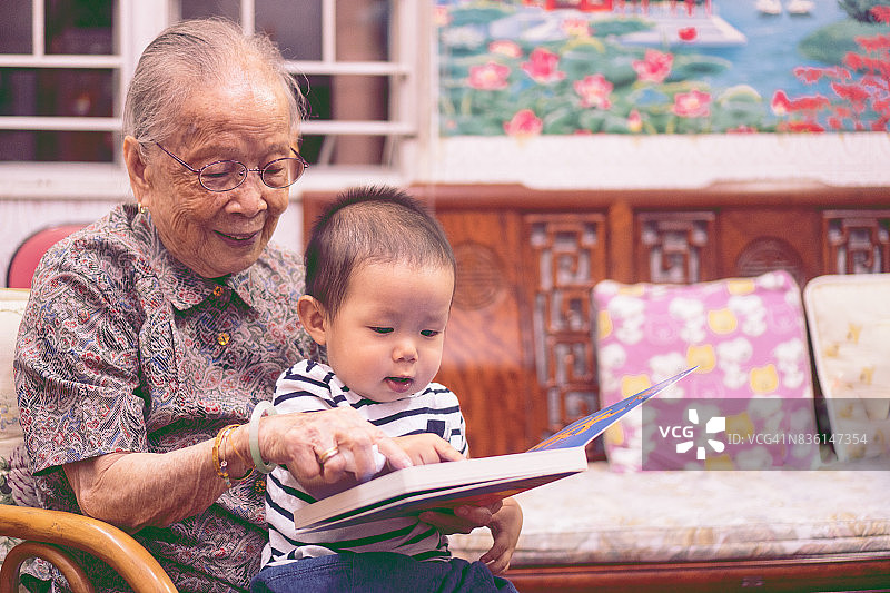 曾祖母高兴地给曾孙讲故事书图片素材