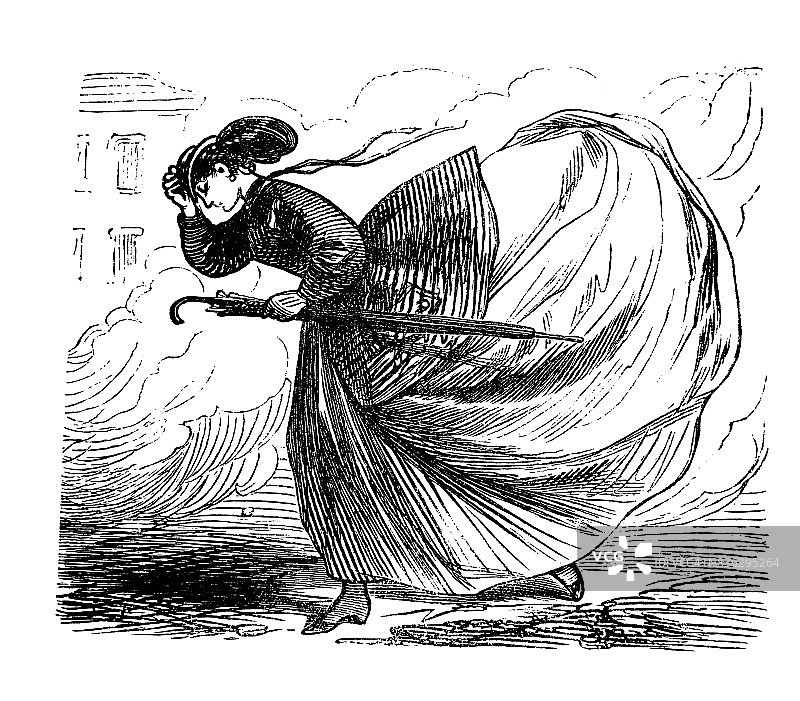 强风中手扶帽子的年轻女人图片素材