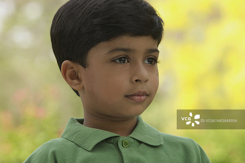 表情严肃的男孩身穿绿色衬衫图片素材