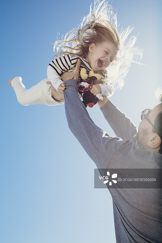 父亲将小女儿抛向空中图片素材