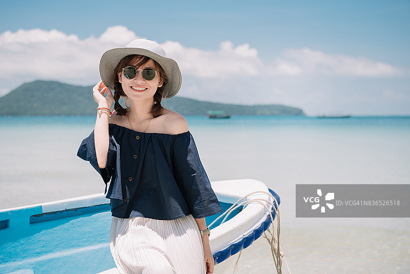 在海滩上露出可爱笑容的美丽越南年轻女子图片素材