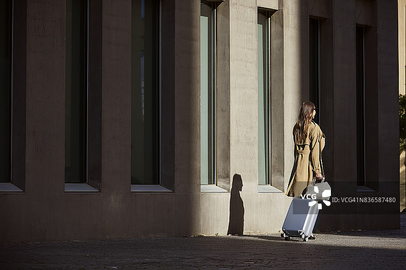行政人员在机场外提着行李的背影图片素材