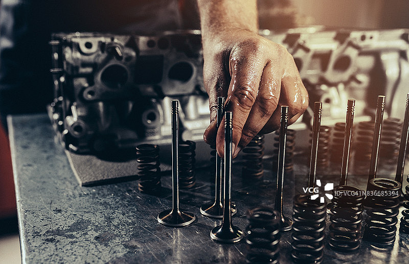 专业汽车修理工在汽车修理店修理V10发动机图片素材