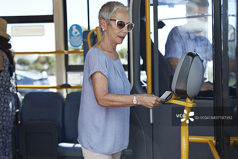 中年妇女使用交通卡支付公共汽车车费图片素材