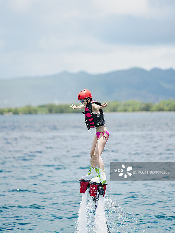 在关岛挑战水上飞板的女人图片素材