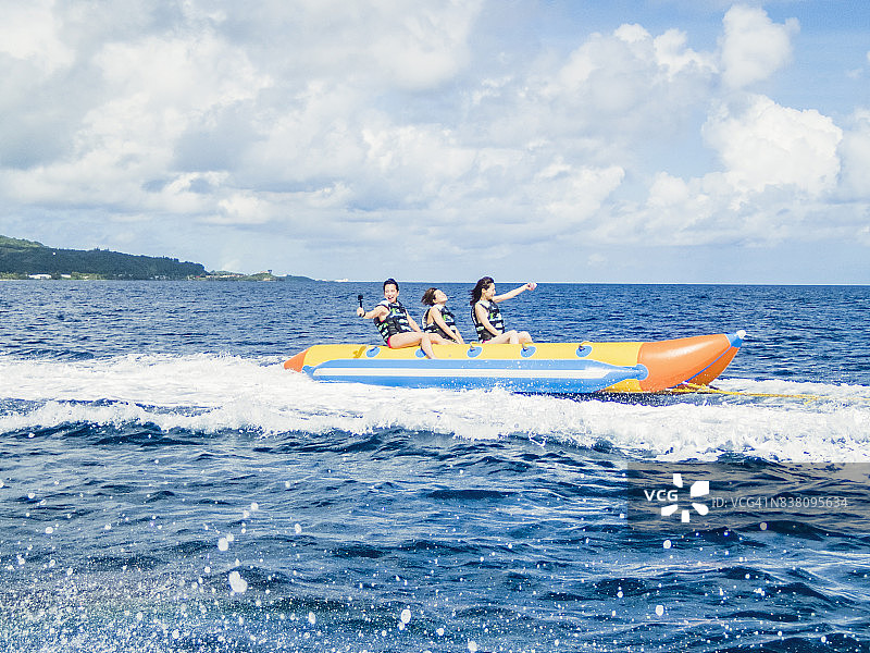 三名女性在关岛乘坐香蕉船图片素材