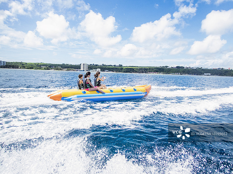 三名女性在关岛乘坐香蕉船图片素材