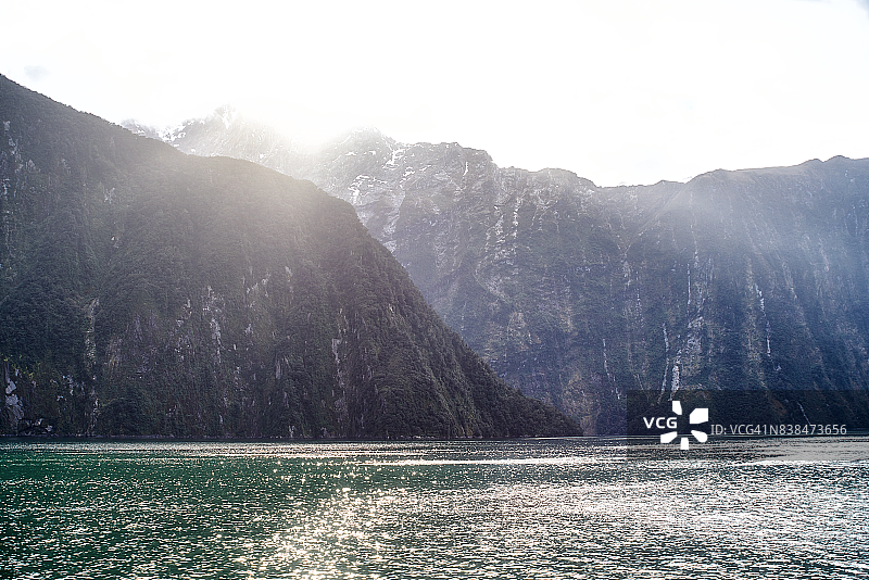 新西兰米尔福德峡湾阳光穿过山边图片素材