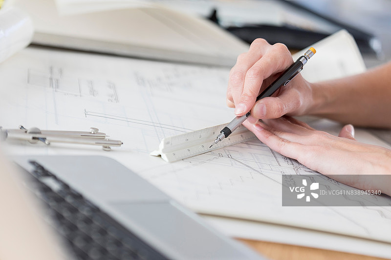 建筑师用比例尺绘制蓝图特写图片素材