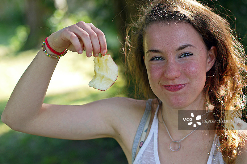 年轻女人展示被咬过的苹果图片素材