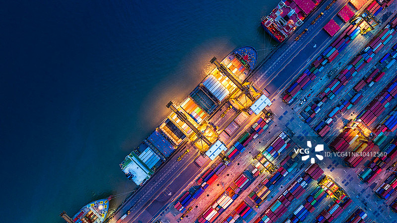 通过起重机在港口运输货物的集装箱船图片素材