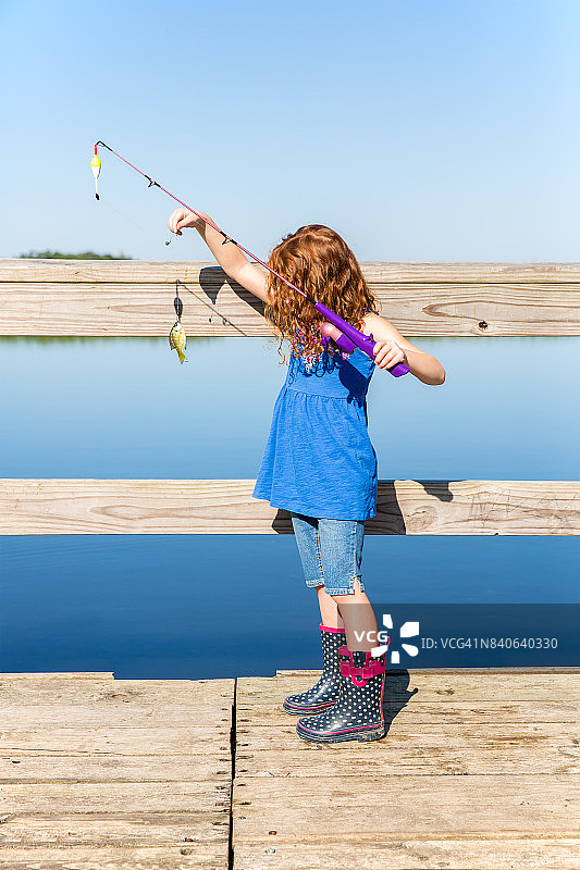 年轻女孩展示刚捕获的翻车鱼图片素材