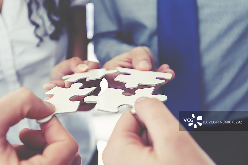 一群商务人士拿着拼图碎片图片素材