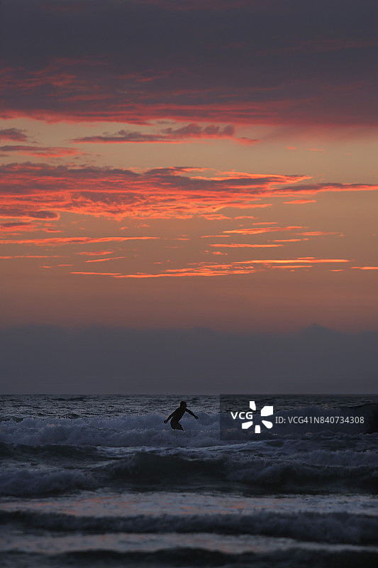 加利福尼亚州圣地亚哥拉霍亚海岸的太平洋日落，冲浪者和游客的热门景点图片素材